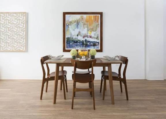 A brown wooden dining table with four chairs and a painting on the wall.