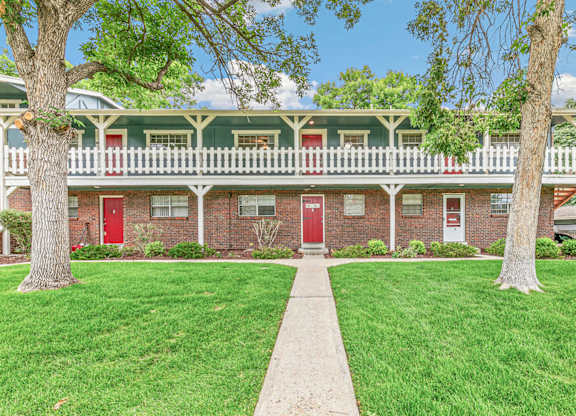 A red brick building with white trim and a green roof.