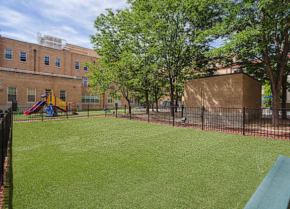 A playground with a green slide and a red slide.