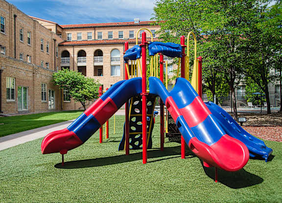A red and blue slide in a playground.