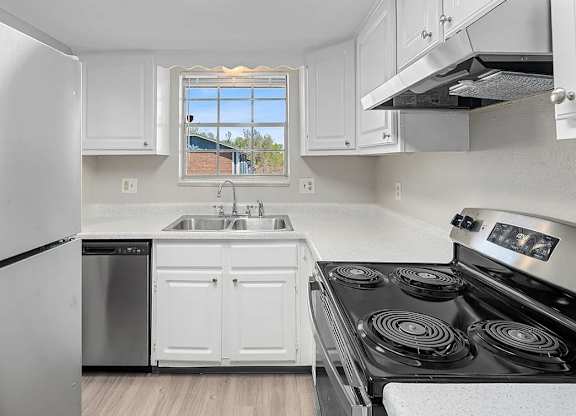 A kitchen with white cabinets and a black stove top.