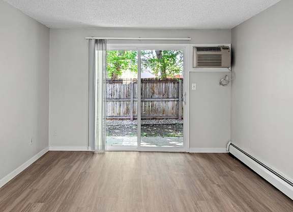 A room with a sliding glass door leading to a backyard.