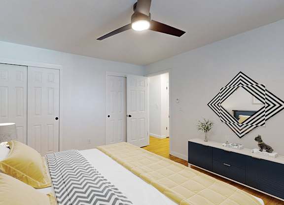 A bedroom with a bed, dresser, and mirror.