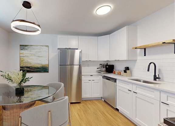 A modern kitchen with a glass table and stainless steel appliances.