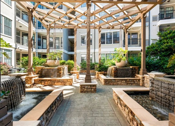 a courtyard with water fountain and seating in an apartment building