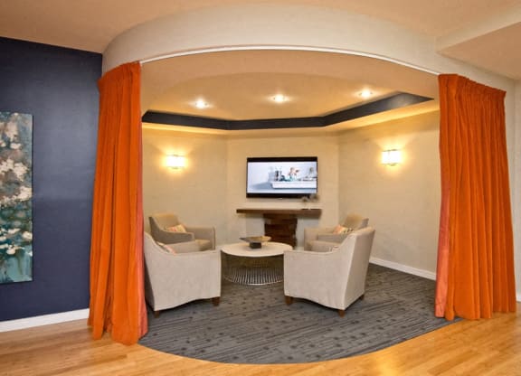 a living room with chairs and a table and a television