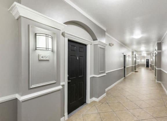 the hallway of a building with a lobby and a black door