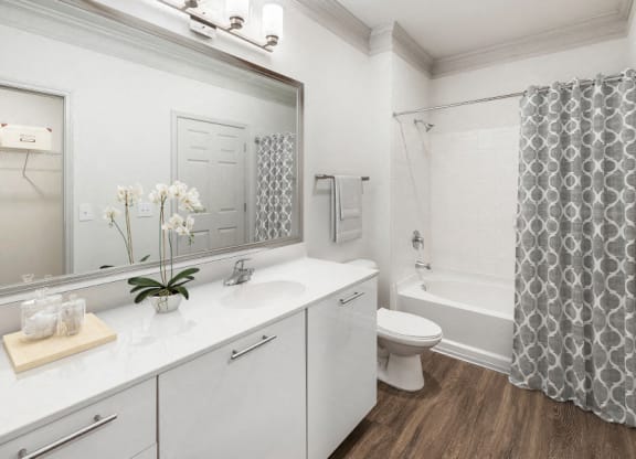 a white bathroom with a shower and a sink and a toilet