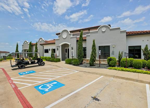A parking lot with a disabled parking sign painted on the pavement.