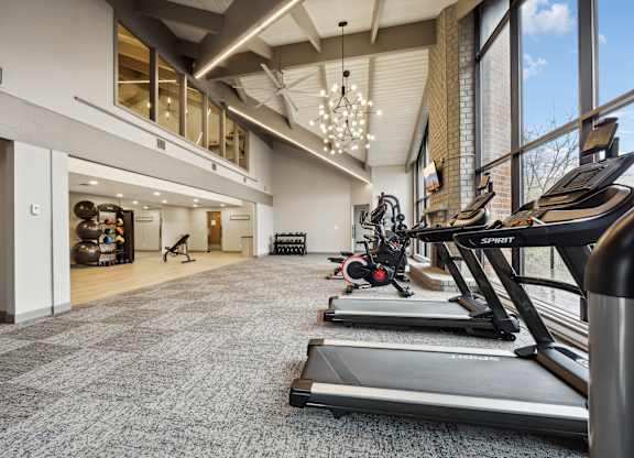 a gym with treadmills and other exercise equipment in the lobby of a building