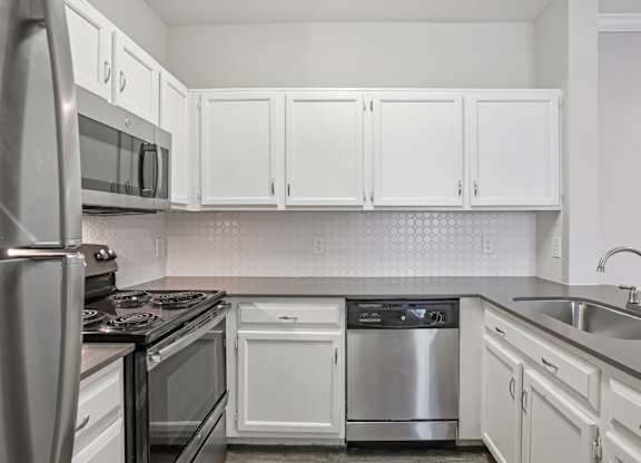 A kitchen with white cabinets and stainless steel appliances.