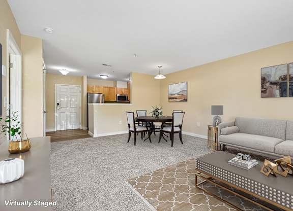 A living room with a grey carpet and a brown coffee table.
