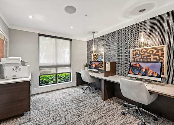 A modern office space with a desk, chairs, and a computer monitor.