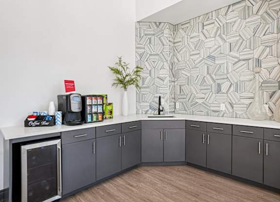 A kitchen with grey cabinets and a white counter top.