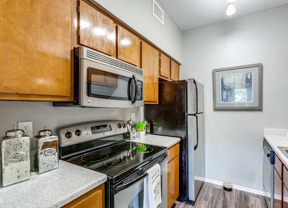 A kitchen with a stove, oven, microwave, and refrigerator.