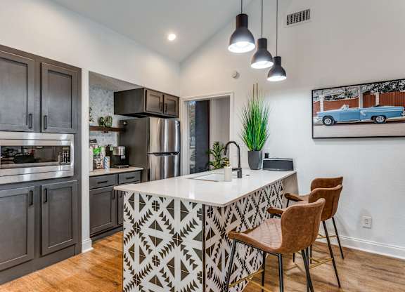 a kitchen with a large center island with a sink and two stools