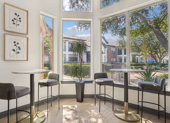 A table with four chairs and two framed pictures on the wall.