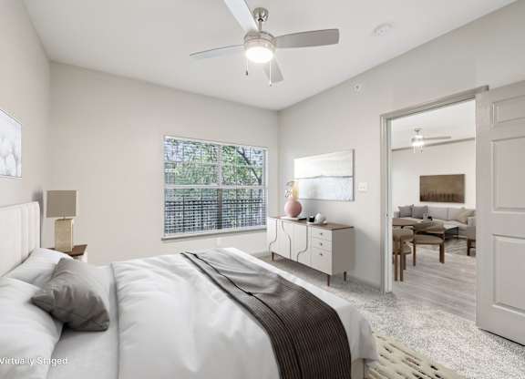 A bedroom with a large bed and a ceiling fan.