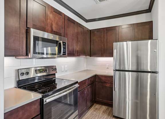 A modern kitchen with a stainless steel refrigerator and microwave.