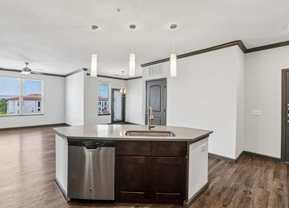 A modern kitchen with a wooden floor and white walls.
