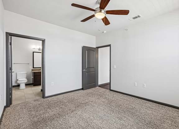 A room with a ceiling fan and a carpeted floor.