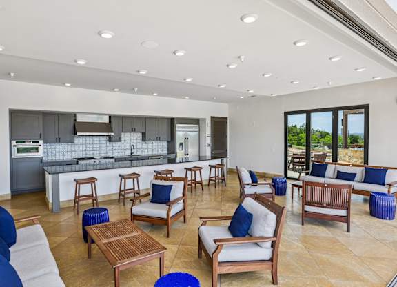 A spacious living room with a kitchen in the background.