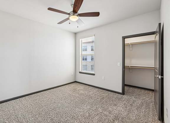 A room with a ceiling fan and a window.