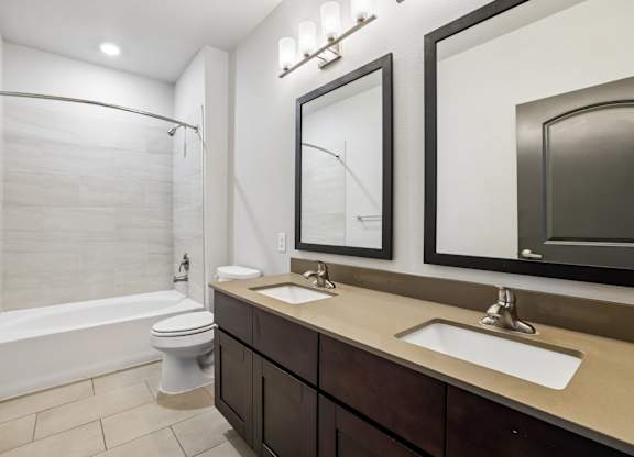 A white bathroom with a toilet, sink, and tub.