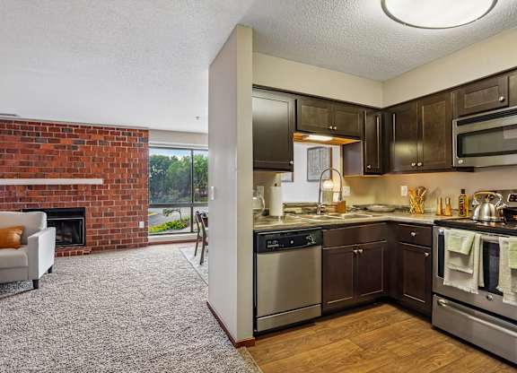 A modern kitchen with dark wood cabinets and stainless steel appliances.