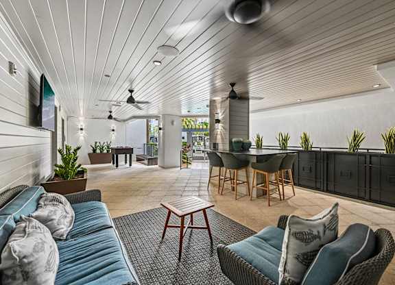 A modern living room with a wooden ceiling and a dining area in the background.