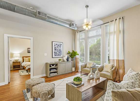 A living room with a brown sofa, a wooden coffee table, and a painting on the wall.