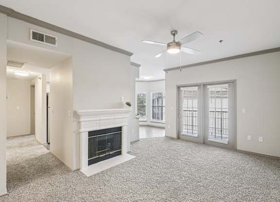A living room with a fireplace and a ceiling fan.