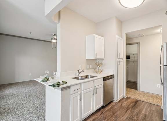 A kitchen with white cabinets and a sink.