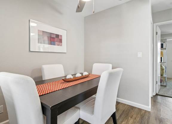 A modern dining room with a black table and white chairs.
