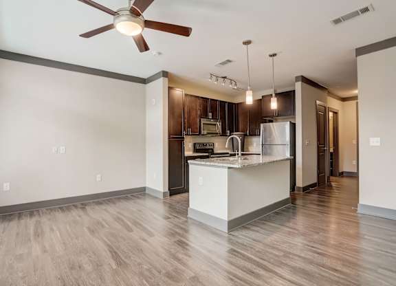 Nashville Apartments - Octave Apartments - Open concept floorplan with wood style floors granite countertops and gourmet kitchen with a large kitchen island and stainless steel appliances