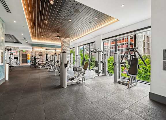 A gym with a variety of equipment including treadmills, weights, and exercise machines.