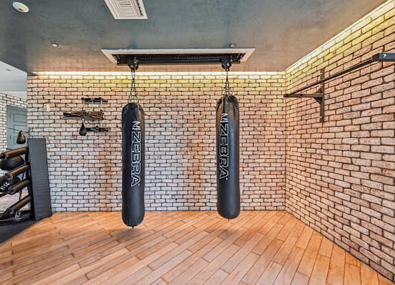 A gym with a brick wall and wooden floor.