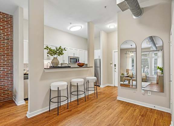 A kitchen with a bar and stools.