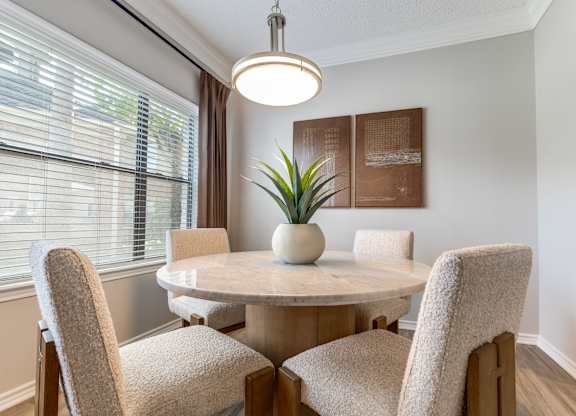 A dining room with a round table and chairs.