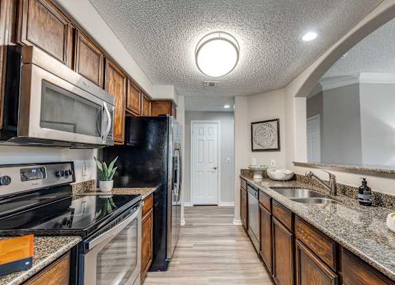 A kitchen with black appliances and wooden cabinets.