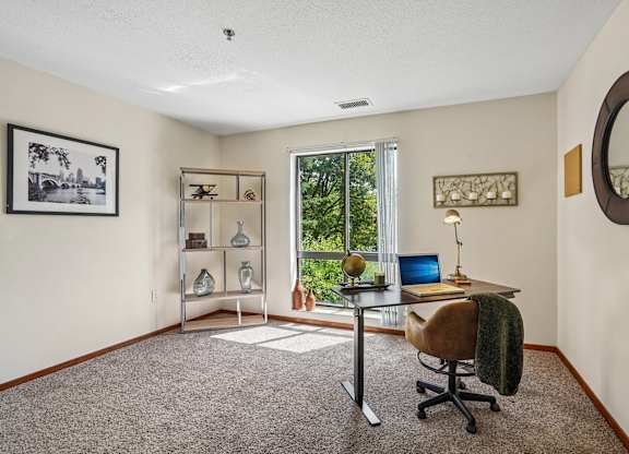 A room with a desk, chair, and a window.