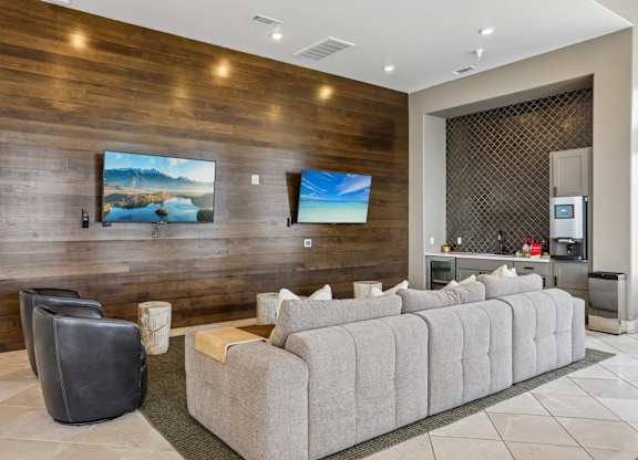 A modern living room with a grey sofa and a wooden wall.