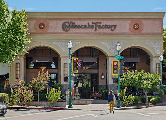 A person is walking in front of a bakery.