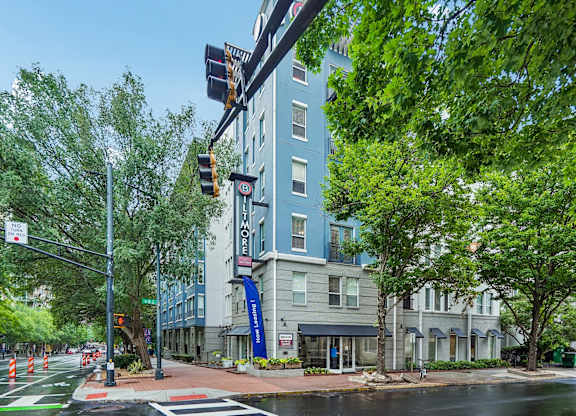 A street view with a traffic light and a building in the background.