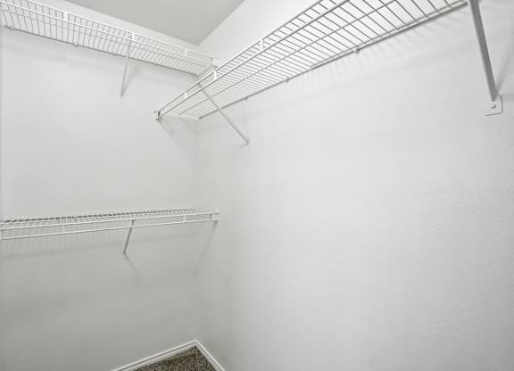 A white wall with a metal shelf on it.