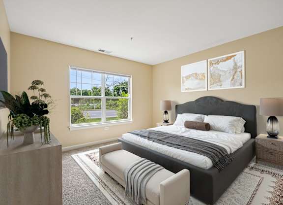 A bedroom with a large bed, a window, and a plant on a table.