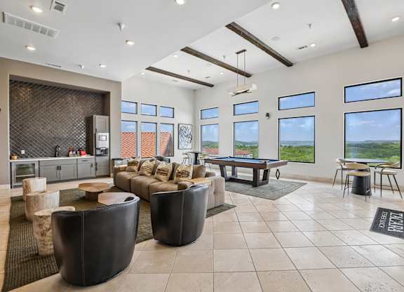 A living room with a pool table and a view of the outdoors.