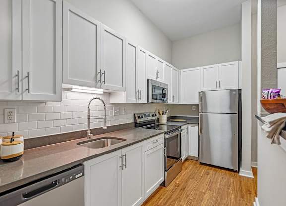 A kitchen with white cabinets and stainless steel appliances.