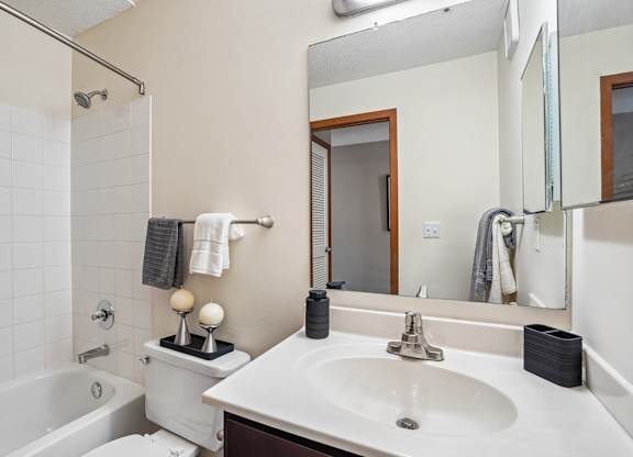 A white sink in a bathroom with a mirror above it.