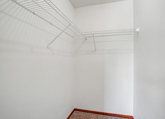 A white wall with a metal shelf attached to it.